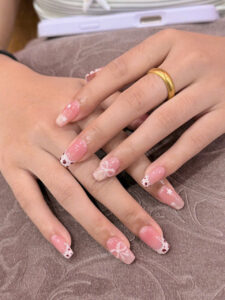 Pink floral clear tip nails at Fame Nails District 7